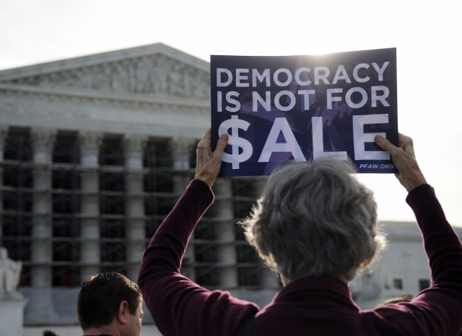 People protest during oral arguments in the case of McCutcheon v. Federal Election Commission at the U.S. Supreme Court in Washington, D.C., October 8, 2013.  The case tests the Constitutional limits of campaign finance laws involving contributions to candidates and political parties and follows the 2010 controversial  Citizens United decision.